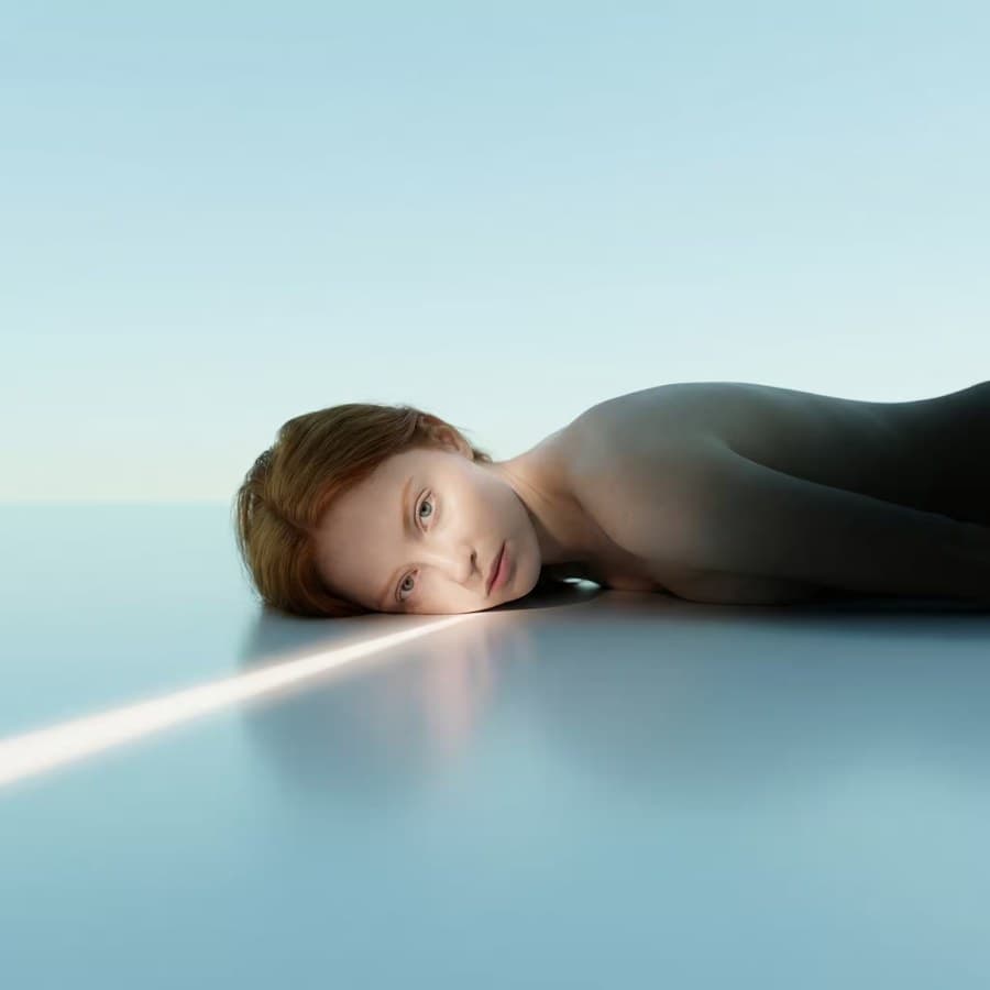 Dreamlike portrait in a pale blue studio